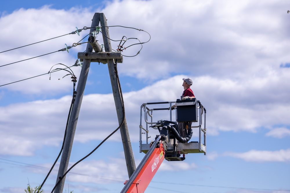 A lineworker in a boom lift working on a utility pole